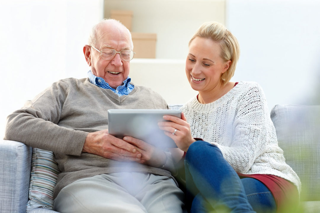 Senior-Man-With-His-Daughter-Using-Digital-Tablet